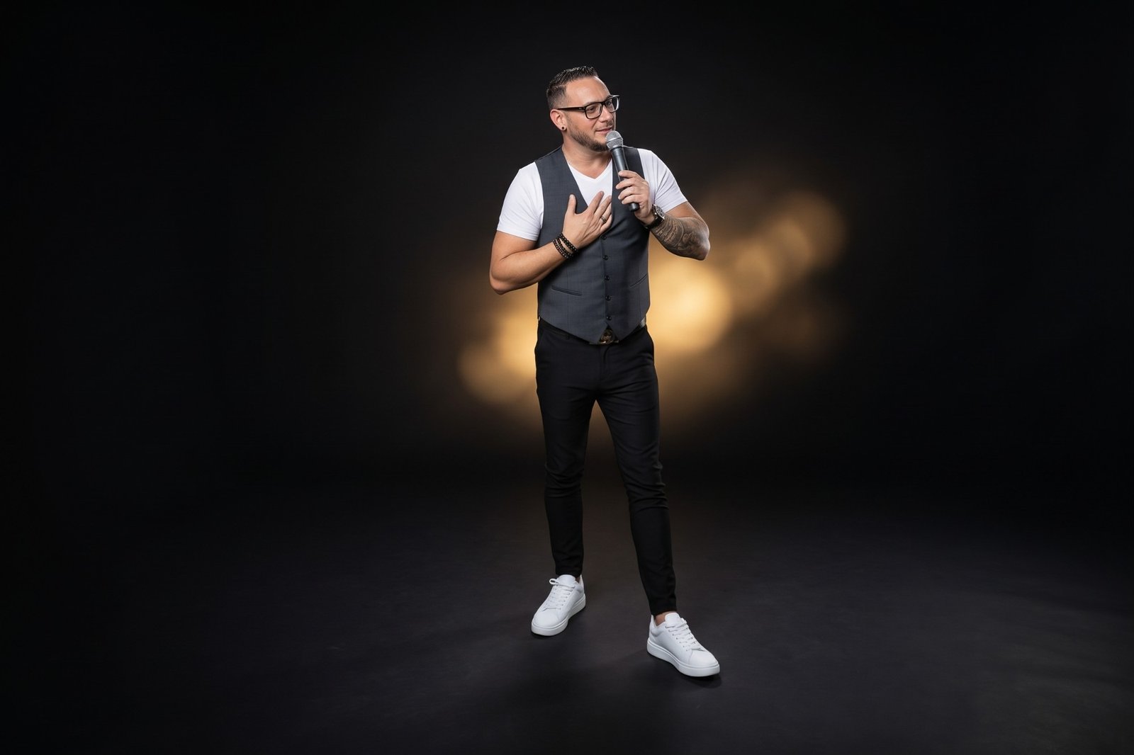 Joël R'Key au micro, la main sur le cœur, devant un halo de lumière dorée