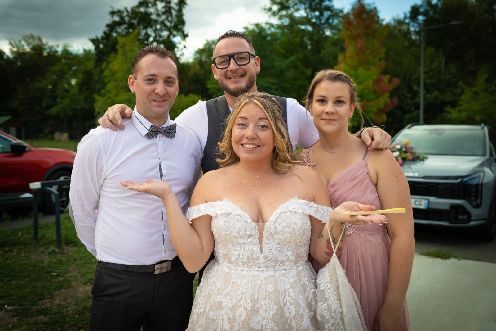 Joël R'Key tout sourire, bras sur les épaules des mariés et d'une invitée, le jour de leur mariage